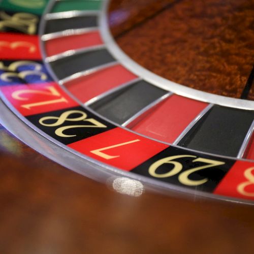 The image features a close-up view of a roulette wheel, displaying red, black, and green numbered sections commonly found in casinos.